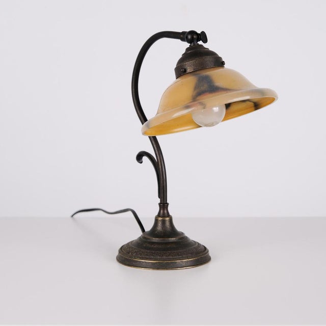 Antique desk lamp made in wrought iron with a yellow frosted glass shade in the style of art nouveau from around the...
