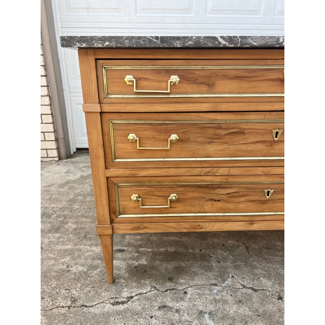 A refined 19th-century French Louis XVI commode crafted from beautifully bleached chestnut, featuring a striking gray...