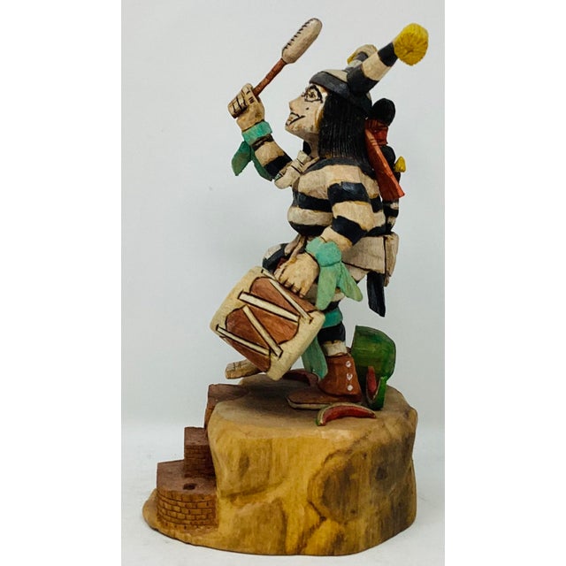 This Hopi Clown Dancer Kachina Doll comes from Native American Milton Howard. Holding a drum and beater, he's stands with...