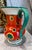 Beautiful art deco pitcher with vibrant yellow, blue, orange, purple, and green colors. It is stamped as Lostro 1QR...