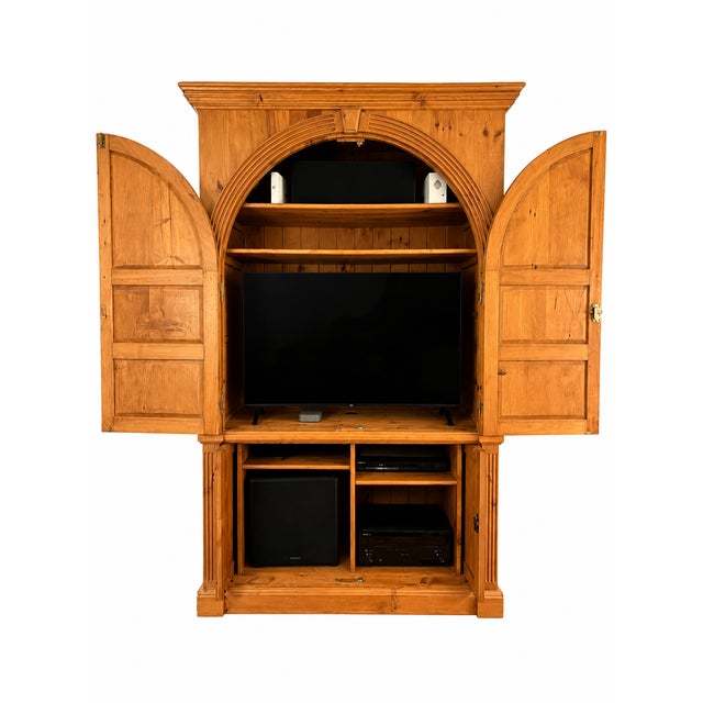 Custom-built solid wood entertainment armoire featuring beautiful architectural detailing and exceptional craftsmanship....