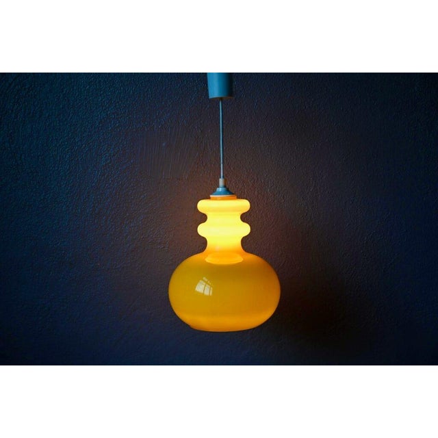 Original and incredibly charming, this 1970s yellow glass pendant light brings a cheerful, soft, and stylish ambiance....