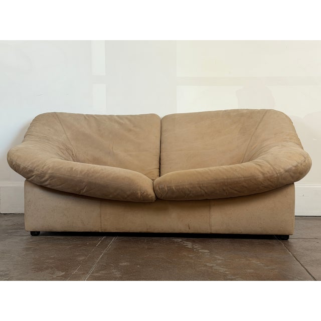 1970's tan leather loveseat by Leolux (Netherlands) in vintage condition. The sofa is faded and it have some spots...