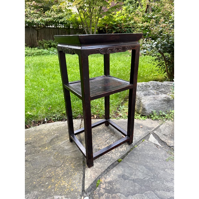 Beautiful antique lacquered Chinese 2-tier hardwood stand / end table, circa early 20th century. The table features hand-...