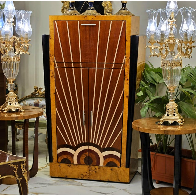 A striking Art Deco cabinet showcasing the distinctive beauty of birdseye maple against a dramatic black frame. The front...