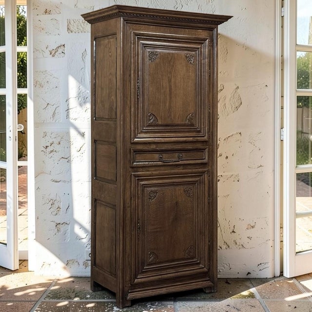 Handsome and beautifully patinated, this early 18th century Country French bonnetière is a distinguished surviving example...