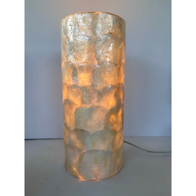 This beautiful handcrafted table lamp is made from natural Capiz shells arranged in a cylindrical form. The translucent...