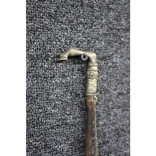 Antique riding crop featuring a decorative sterling silver horse hoof handle with engraved scrollwork detailing. The...