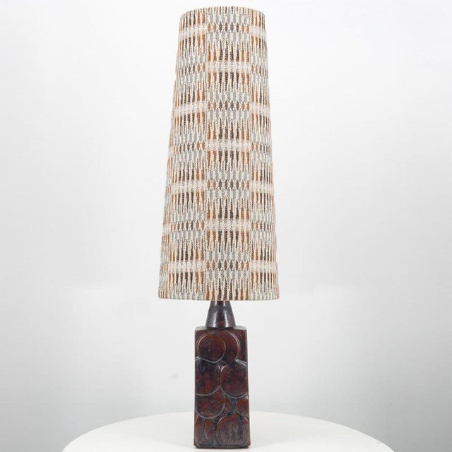 A brown ceramic floor lamp with circular pattern. Sculptural piece, made of handmade ceramic in warm tones, with a new...