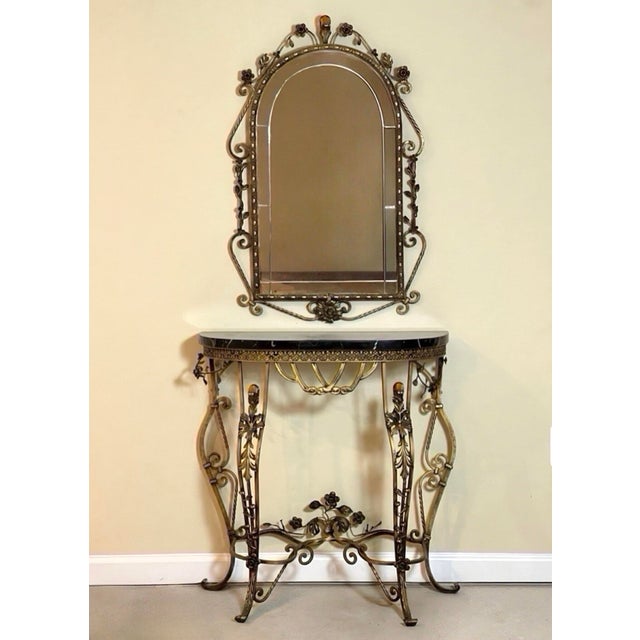 Oscar Bach attributed gilded iron demilune console and mirror with a black marble top, c. 1920. A boldly sculptural set...