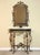 Oscar Bach attributed gilded iron demilune console and mirror with a black marble top, c. 1920. A boldly sculptural set...
