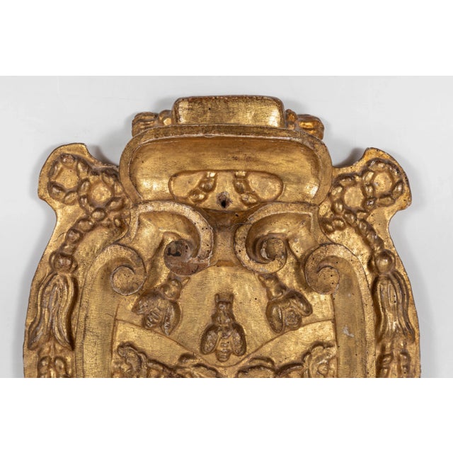 Relief carved, gessoed and 22-karat gold gilded, Italian bishop's crest featuring three bees amidst foliate scrolls,...