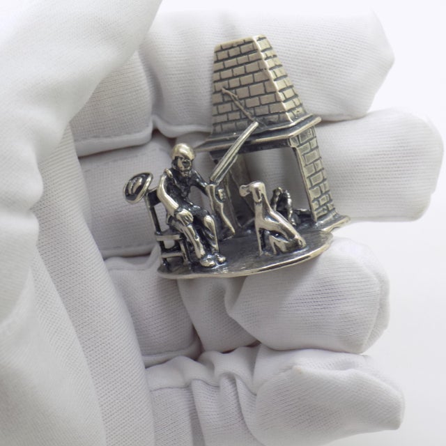 Vintage solid silver narrative miniature figurine depicting a hunter seated with his dog in front of a fireplace, crafted...