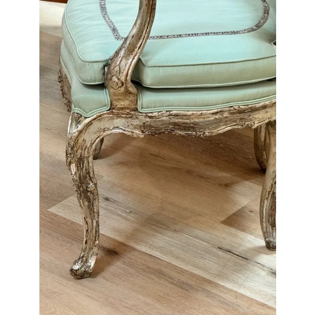 A Venetian Silvered Open Armchair, Late 18th Century, with pale green silk upholstery and seat cushion. This sculptural,...