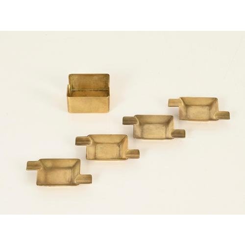 Stunning and super stylish Mid-Century set of four stackable ashtrays with matching holder, entirely crafted in solid...