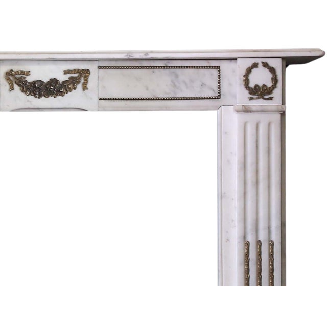 Statuary marble early 19th c. chimneypiece in the Louis XVI style with decorative brass ormolu mounts Overall: 47"w x 40...