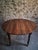 Antique walnut drop-leaf dining table from France, dating from around 1900. The table has a round top with two hinged...