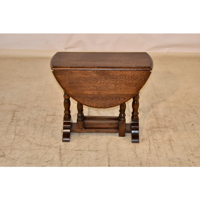 Late 19th century small oak side table with drop leaves from England. The top has a beveled edge, and has lovely graining...