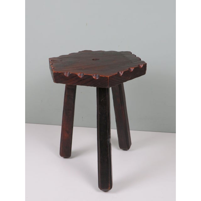 A sculptural mid-20th-century stool handcrafted in Spain, carved from solid wood and defined by its expressive vernacular...
