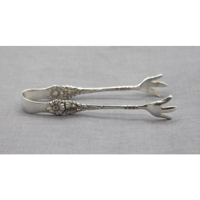 Harlequin sterling silver sugar cube tongs by Reed & Barton, 1958-76. Deep daisy flower motif. Rarely found. 0.75 troy oz....