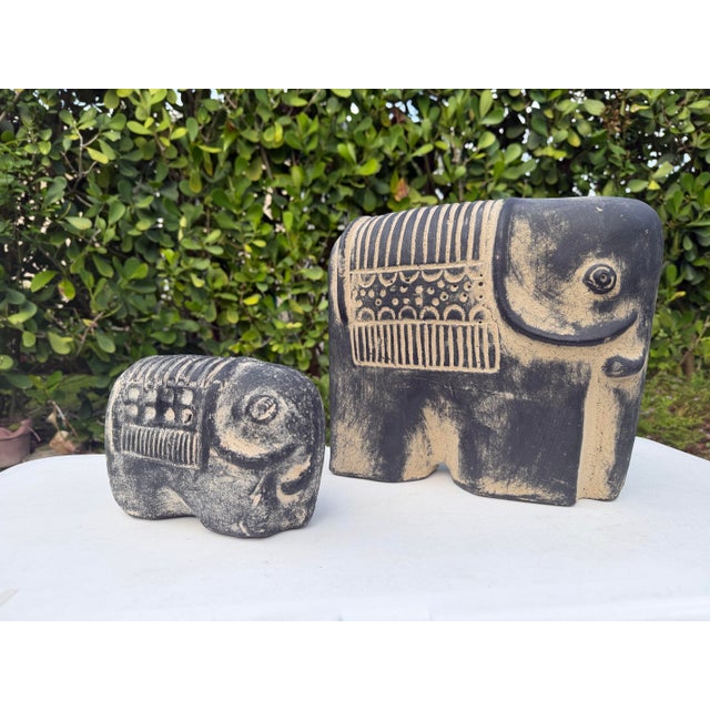 A striking graduated pair of vintage terracotta elephant sculptures finished in a hand-rubbed blackwashed patina that...