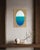 A pale oval deepens from soft sky blue at the top into a rich, saturated teal at its base, the gradient built in thin,...