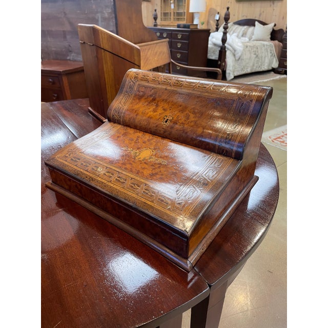 An exquisite vintage portable writing desk crafted from richly grained burlwood, highlighted by intricate inlaid borders...