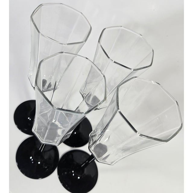 These striking octagonal flutes are held up with chic, liquid black opaque stems. Their style is reminiscent of the 80s...