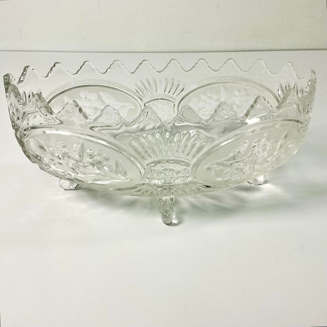 This is a Mid-Century pressed glass Oval Serving Bowl. It features a sawtooth rim and flora botanical frosted accents. The...