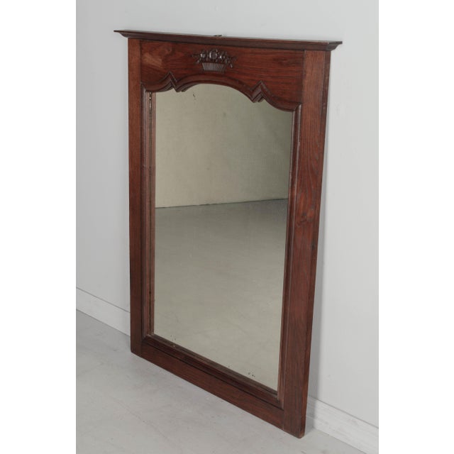 A Country French oak trumeau wall mirror with simple carved flower basket decoration at the top. Original mirror has nice...
