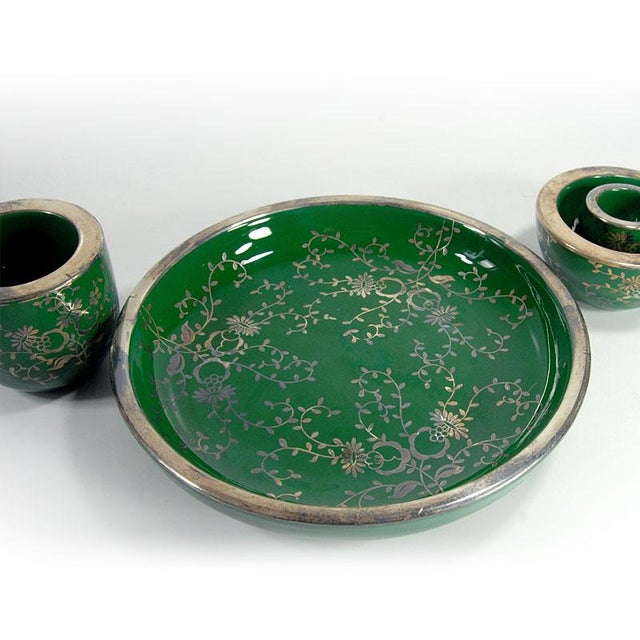 A highly decorative tableware set made of ceramic. All elements are glazed with a high-gloss, deep emerald color. They are...