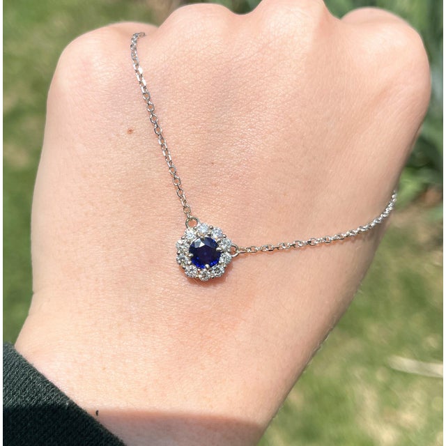 This art deco necklace features a deep blue sapphire set in a floral diamond halo mount with a lobster clasp chain. A...