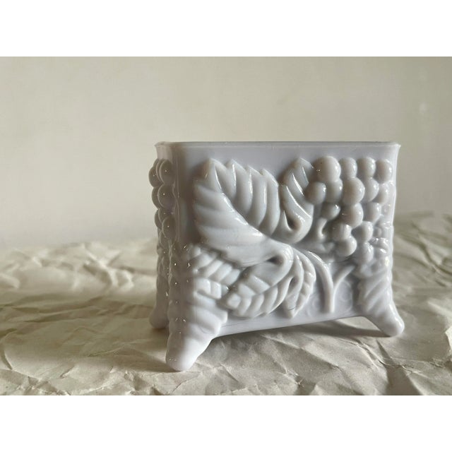 A vintage glass footed tabletop card/ toothpick holder decorated with bunches of grapes amid textured leaves. This piece...