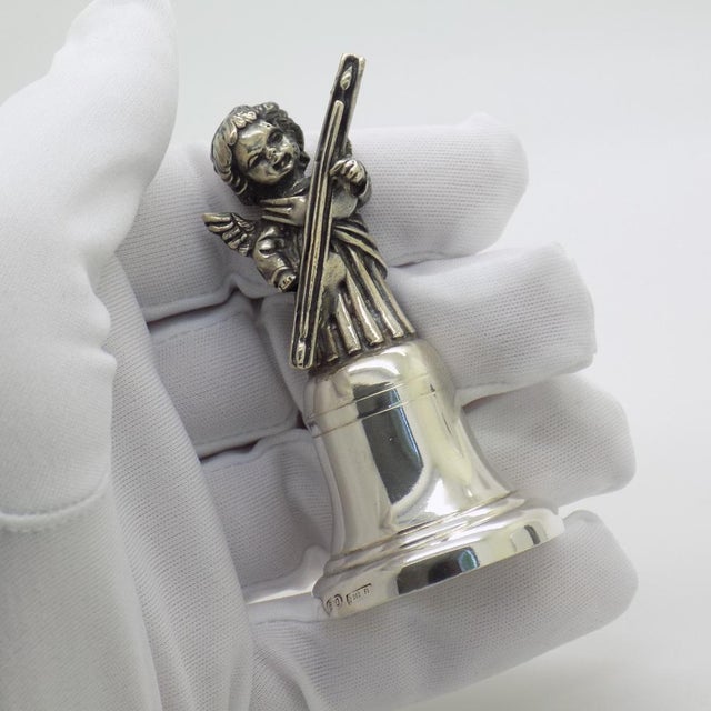 A vintage object in the form of a bell with an angel and an antique musical instrument, crafted in florence, italy between...