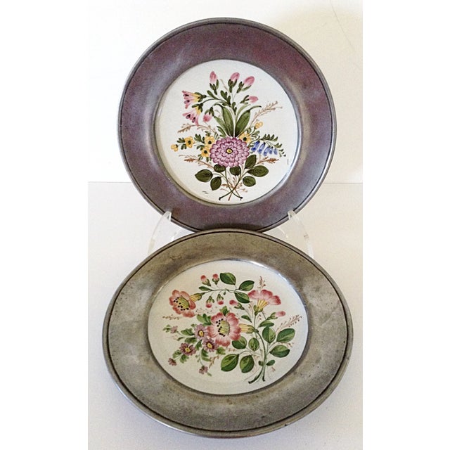 A pair of beautifully hand painted floral plates from Bassano Italy securely mounted with pewter rims that have their own...
