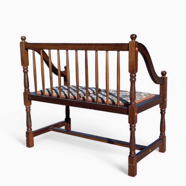 Vintage Spindle Back Wood Settee with Floral Cushions. A vintage spindle-back wood settee with curved arms, turned posts,...