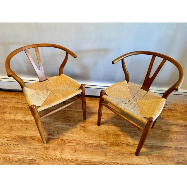 A handsome pair of chairs in the manner of Hans J. Wegner for Carl Hansen & Son CH24, well crafted in a honeyed brown...
