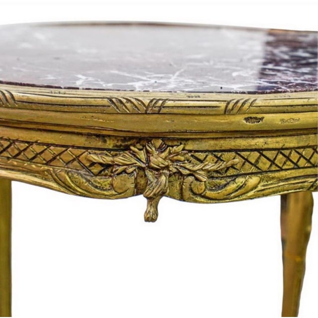 French Louis XV-style gilt bronze side table with figural mounts, floral motifs, cabriole legs, and red veined marble...