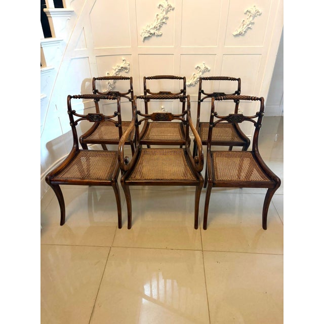 A very elegant set of antique English Regency mahogany dining chairs consisting of five singles and one carver, retaining...