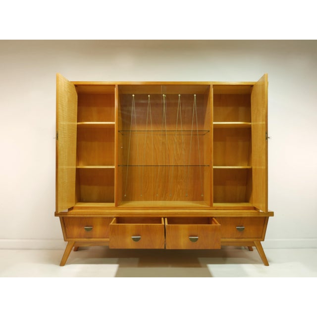 An exceptional living room cabinet from the 1960s with elegant mid-century proportions and a rare, two-part construction....