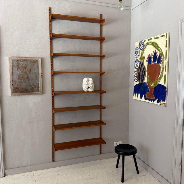 Designed by Kai Kristiansen, this elegant wall-mounted shelving system is a fine example of Danish Modern design from the...