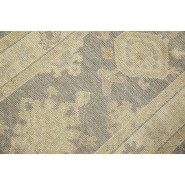 This modern Turkish Oushak rug is a stunning piece of art that has been handwoven using traditional techniques by skilled...