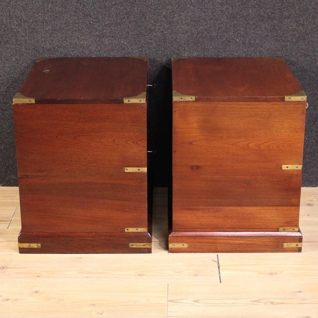 Pair of English bedside tables from the mid-20th century. Naval-style furniture carved from exotic wood with bronzed metal...