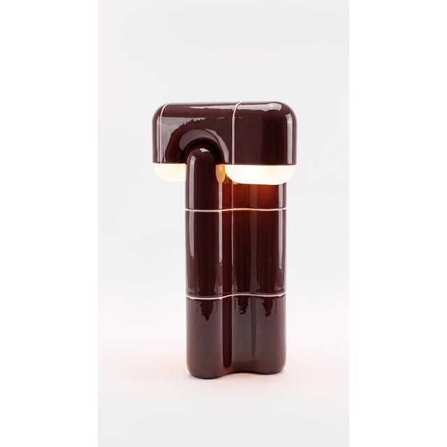 Part light, part totem. This tall table lamp stacks the collection's curved-tile module into a slender column that draws...