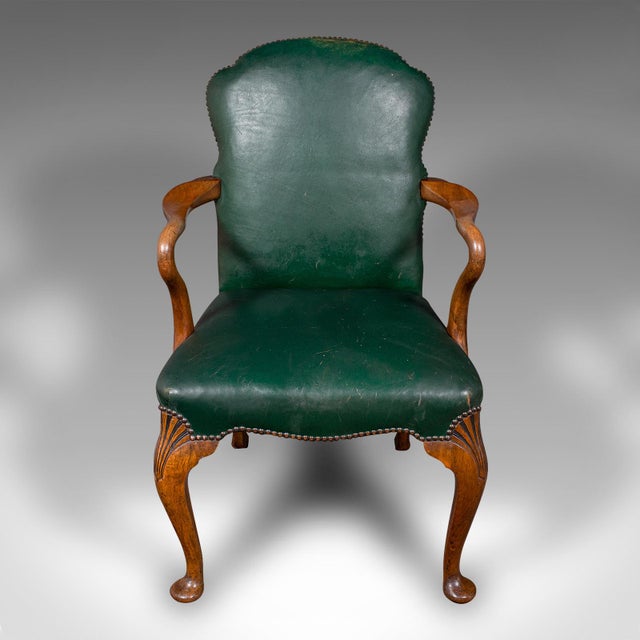 This is an antique clerk's desk chair. An English, beech and leather elbow seat, dating to the early 20th century, circa...