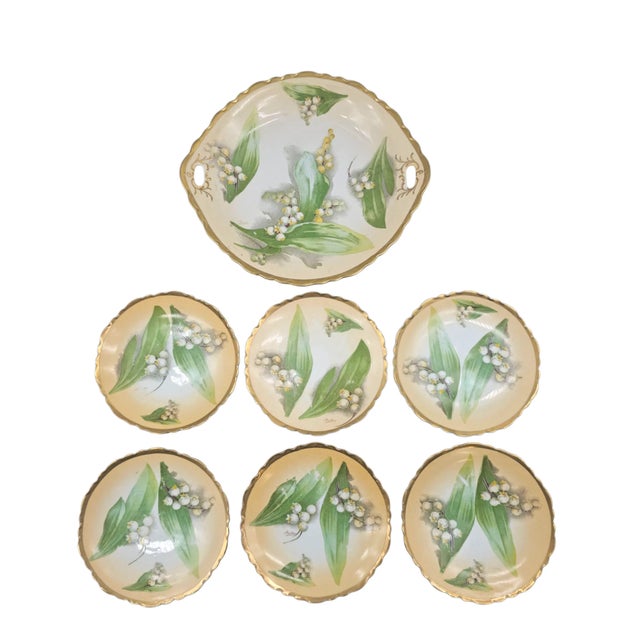 A refined set of porcelain plates by O.& E.G. Royal Austria, delicately decorated with Lily of the Valley blossoms. Each...