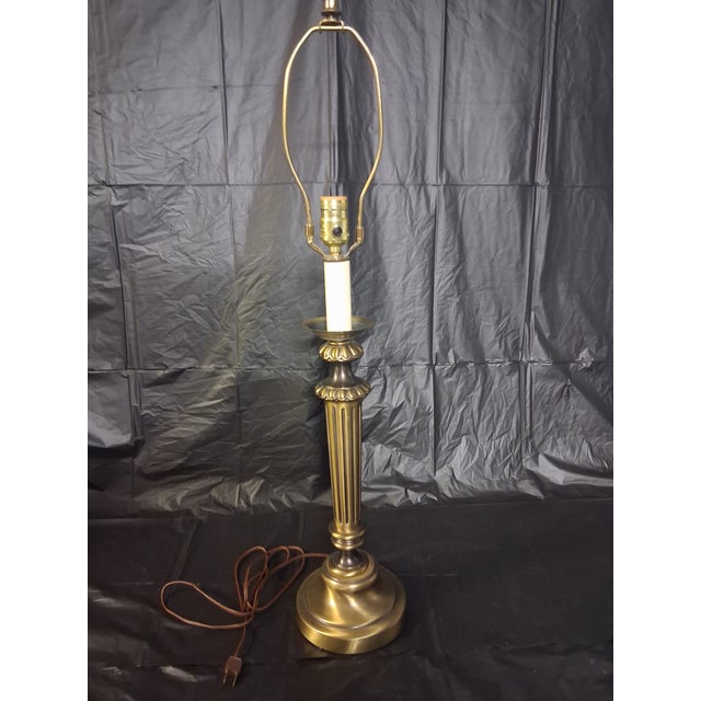 Gorgeous vintage neoclassical fluted brass column table lamp in the style of Stiffel Lamps. It features an ornate stepped...