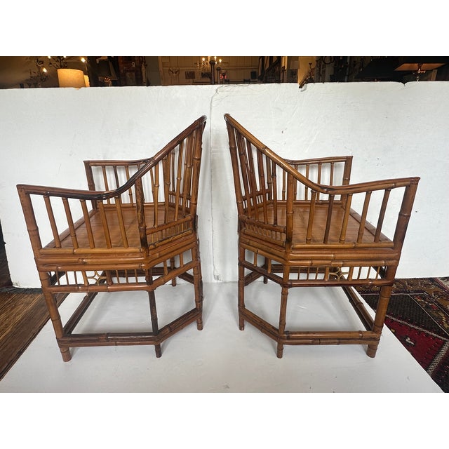 Pair of lovely bamboo and rattan chairs having handpainted birds and custom cushions. 21” W x 35.5” H x 21” D Arm 27” H...