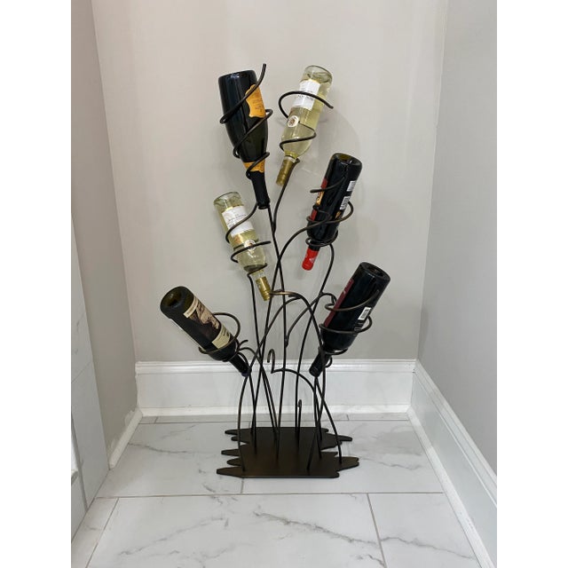 Vintage unique sculptural wrought iron wine rack that holds six full bottles of wine or champagne. Featuring a unique base...