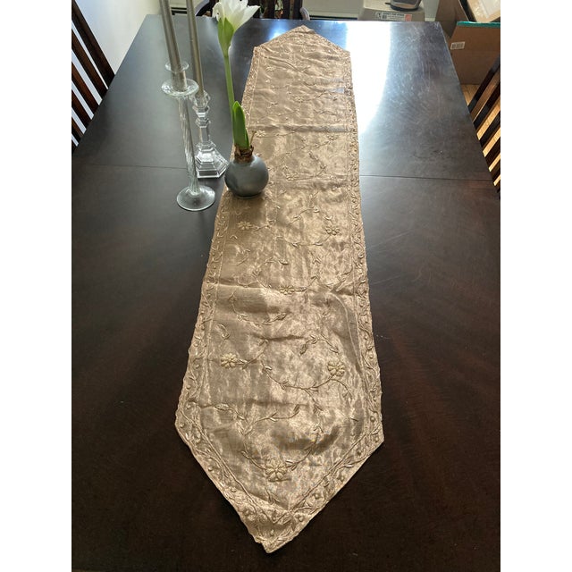 Crafted with exquisite care, this brass silk organza table runner from Sethi & Sethi Home is a testament to intricate...